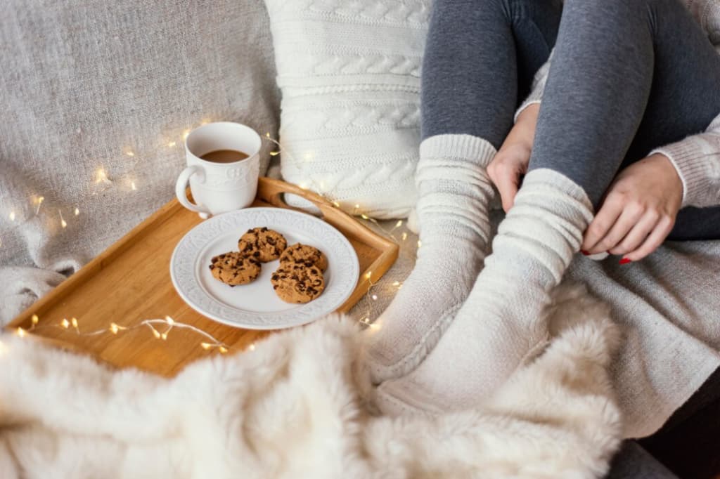 coffee, cookies on the tray, and a woman dressed in gray leggings and white knit socks