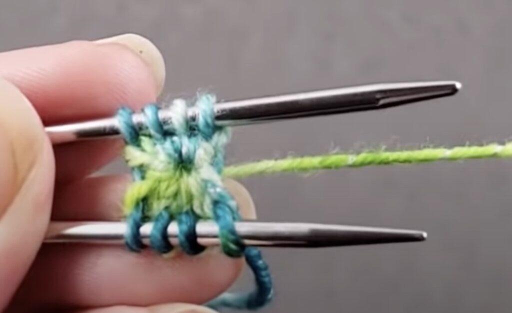 hands hold knitting needles and threads for knitting