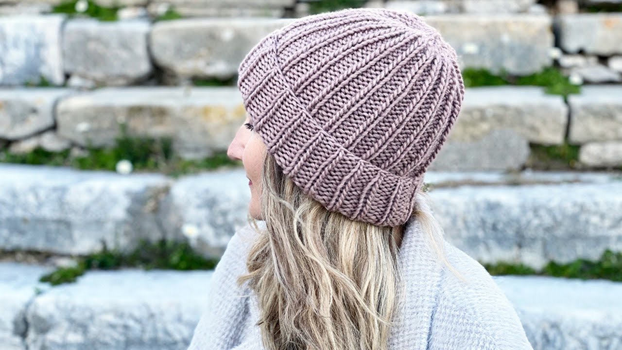 Girl in a hat on a background of stones