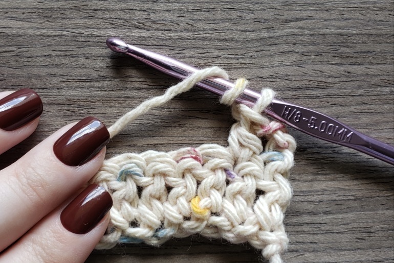 Fingers on threads with a crochet hook